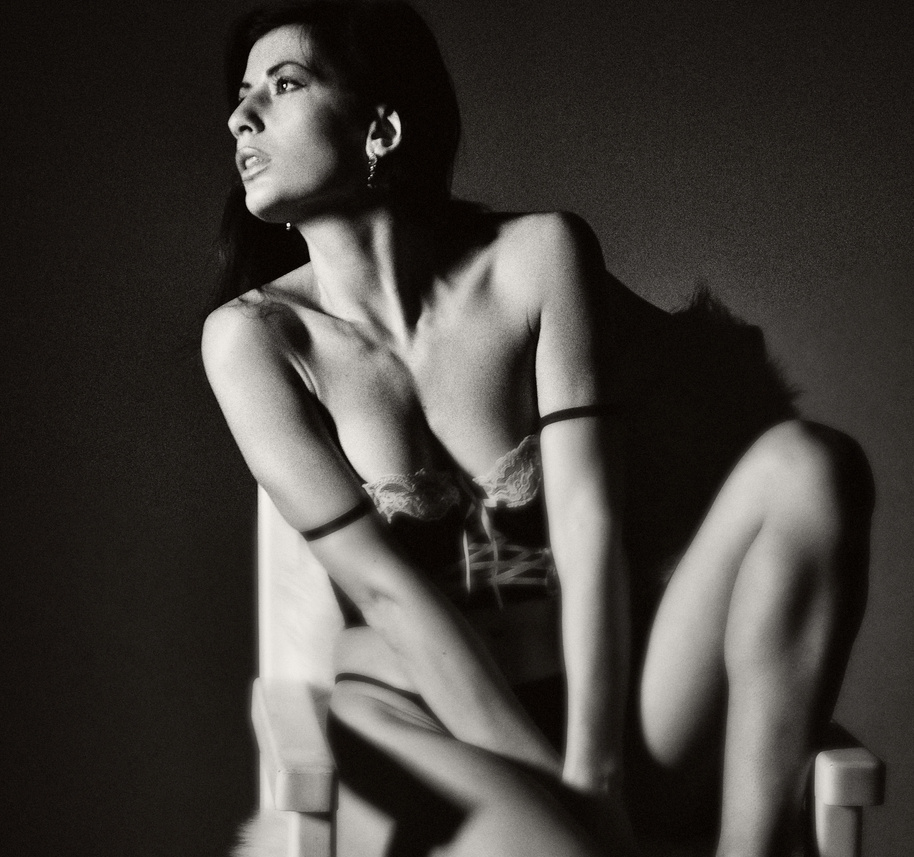 Woman in Sexy Lingerie Sitting on a Chair while Looking Afar